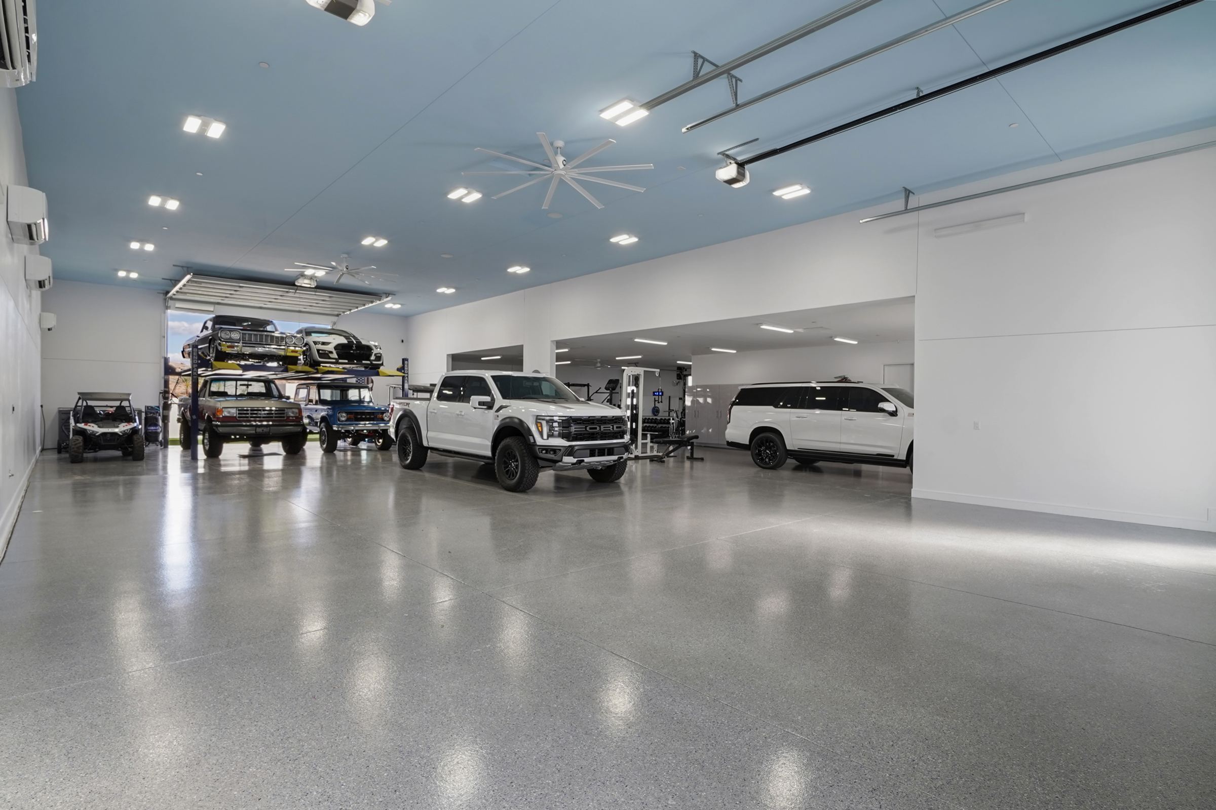 Inside the 4,480 sf garage at 6269 Avienda De Las Colinas, with the car lift, trucks and SUVs