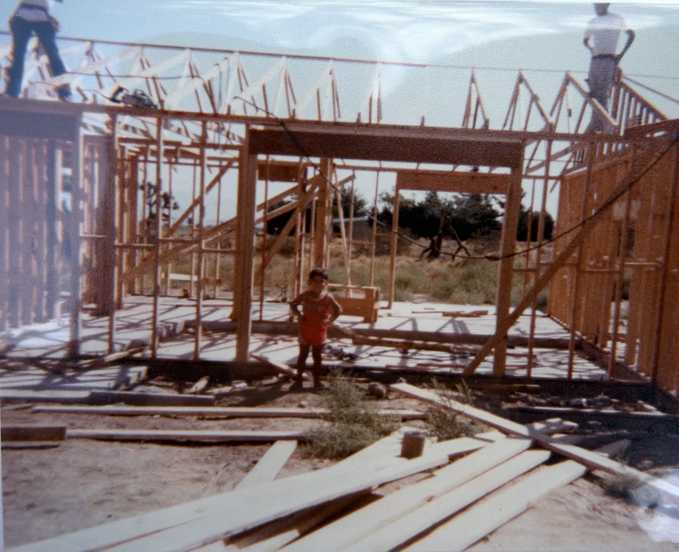 Jose as a kid, standing in the framing of a house under construction